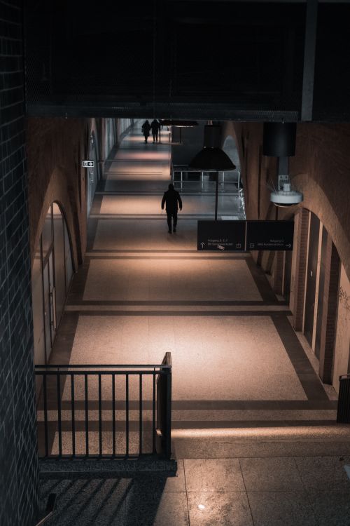 Free Moody corridor in Berlin's train station with a lone person walking. Stock Photo