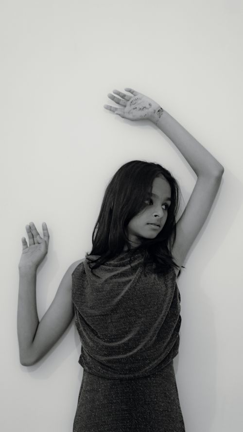 Free Artistic black and white portrait of a young woman in a contemplative pose against a plain background. Stock Photo