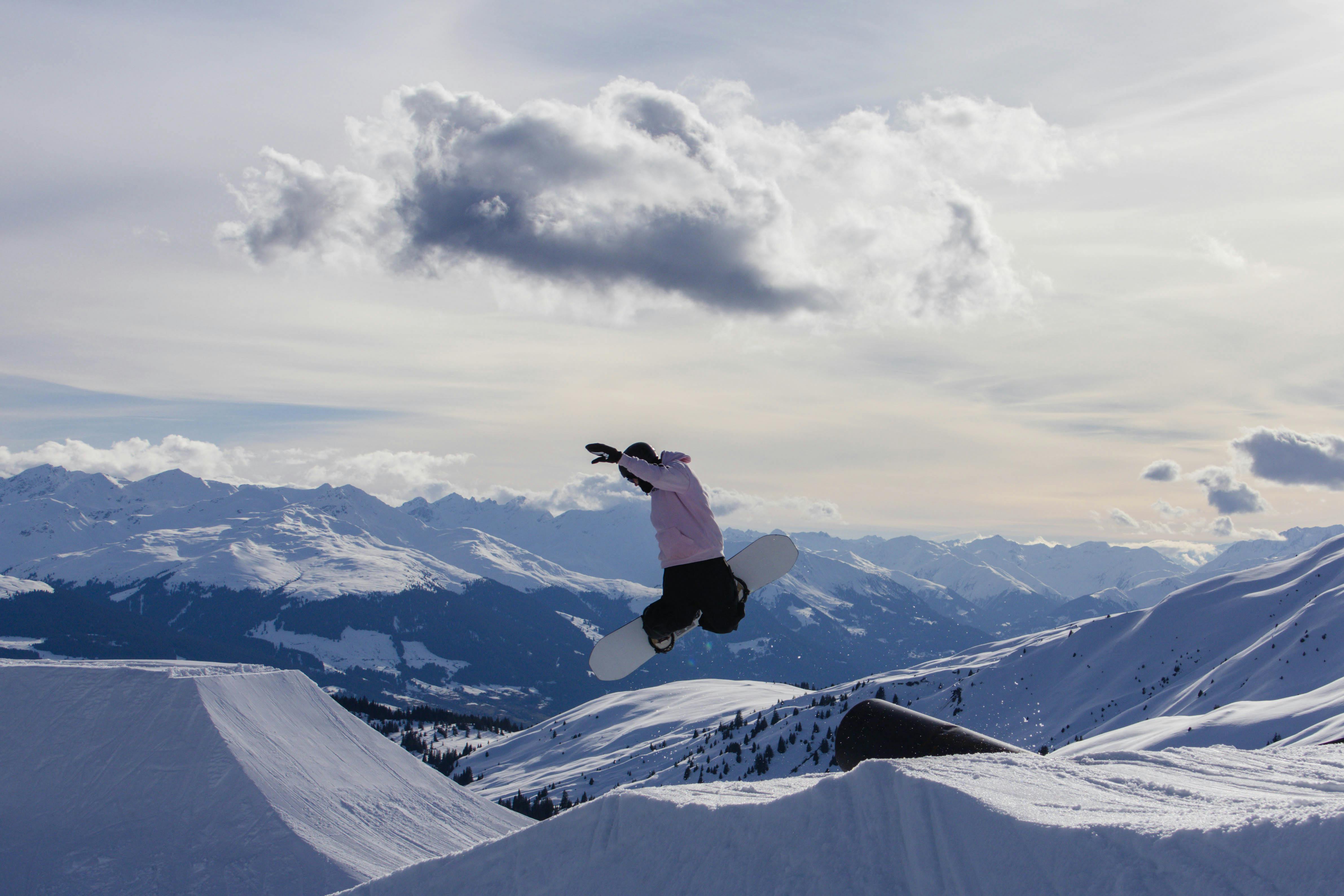 Exciting jump by a snowboarder in Laax ski resort, capturing the thrill of winter sports in the Swiss Alps.