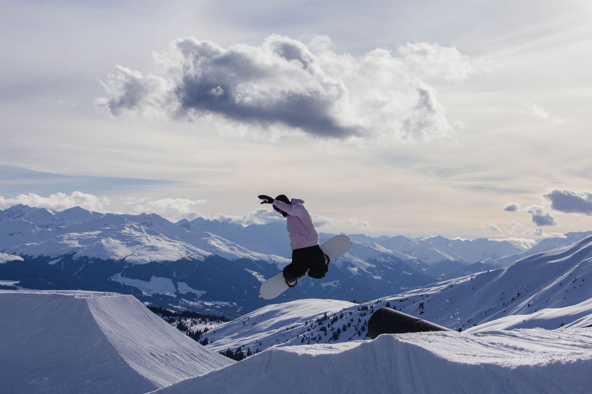 Dağlık alanda snowboard yapan bir sporcu