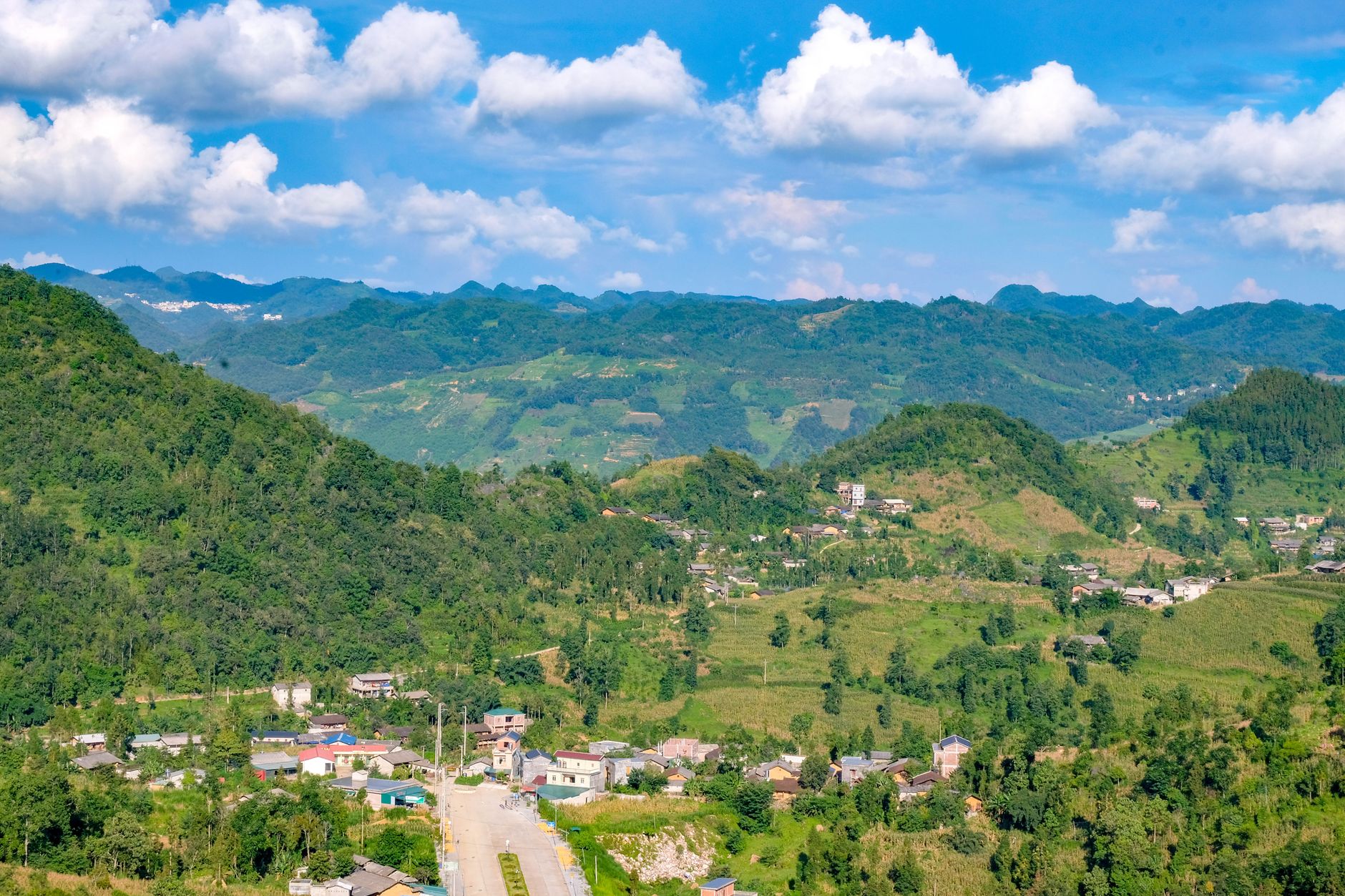 Breathtaking mountain landscape with lush greenery and small village in Ha Giang, Vietnam.