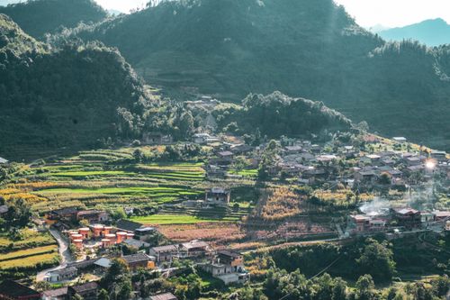 Free Stunning aerial view of Hà Giang's terraced fields and village in vibrant sunlight. Stock Photo