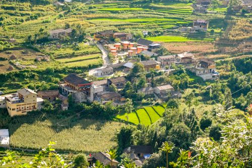 Free Aerial view of a picturesque village surrounded by lush green rice fields in Hà Giang, Vietnam. Stock Photo