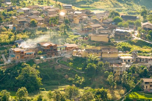 Free Picturesque aerial view of a village in Hà Giang, Vietnam, surrounded by lush greenery. Stock Photo