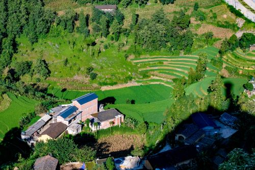 Free Aerial view of lush green rice terraces and rural buildings in Hà Giang, Vietnam. Stock Photo