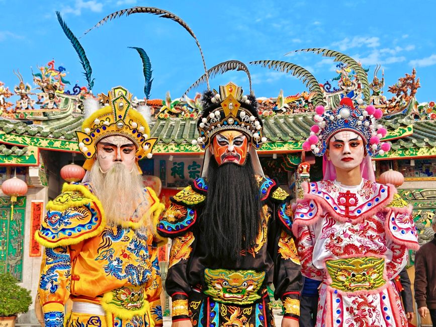Fotomural Exhibición vibrante de trajes y maquillaje de la ópera china tradicional contra un elaborado fondo de templo.