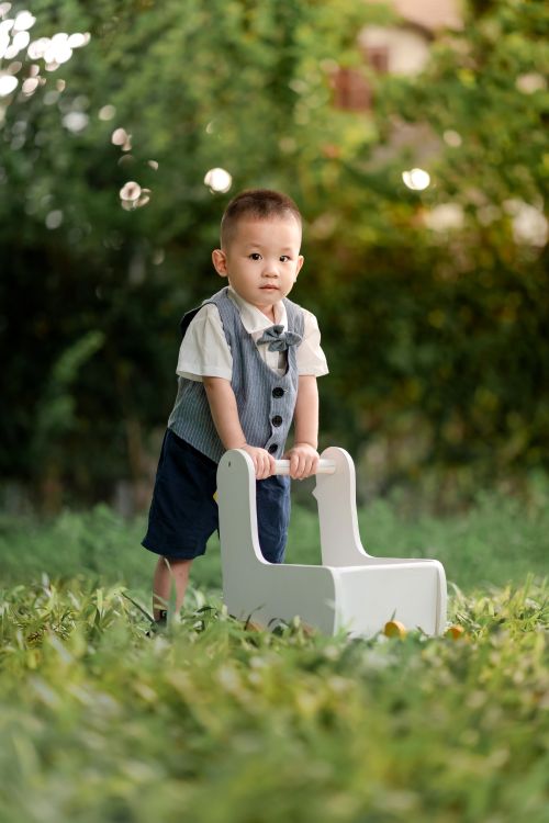 Free Charming toddler in formal attire enjoying playtime outdoors on a summer day. Stock Photo