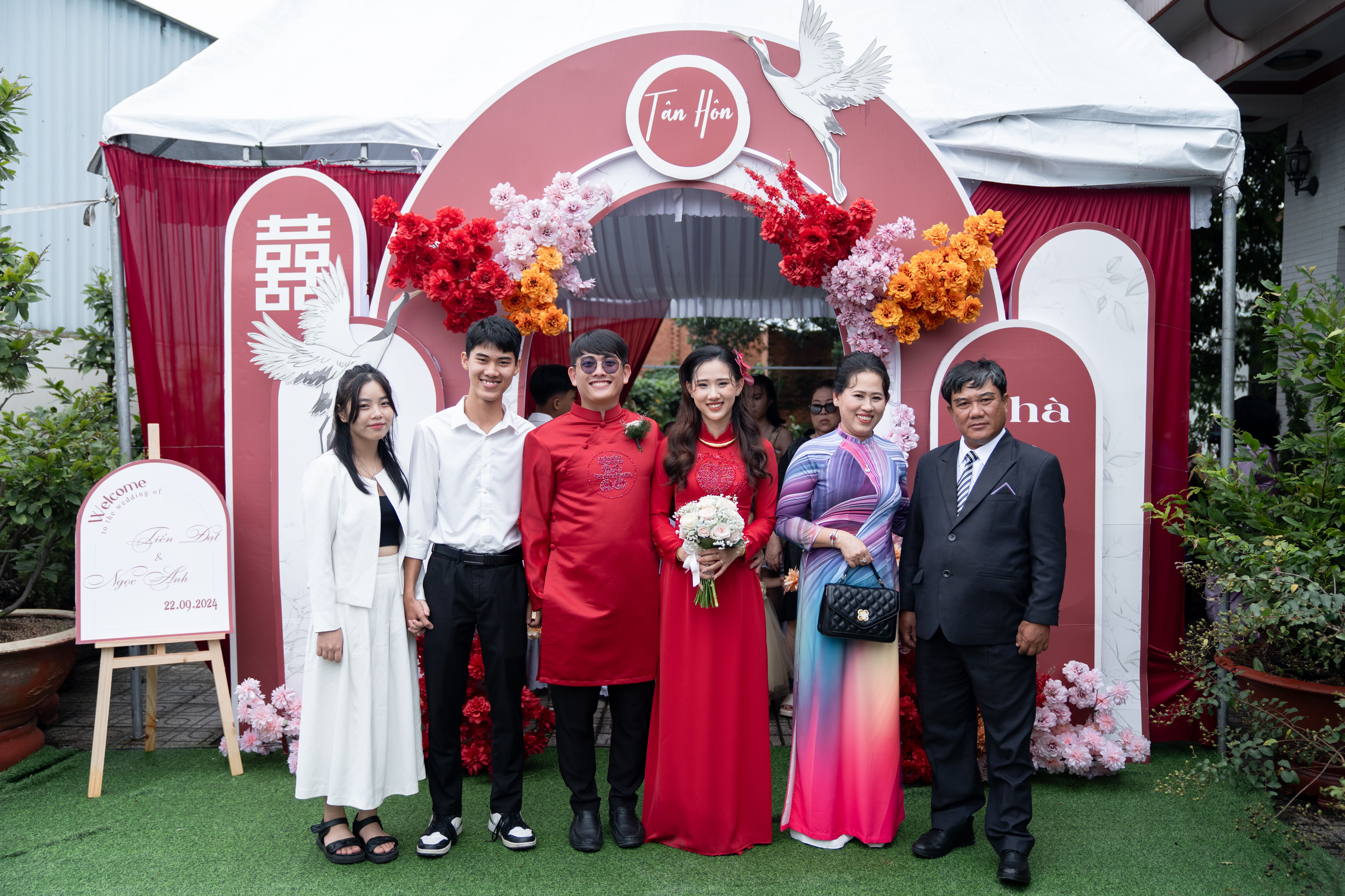 Family portrait at a traditional wedding ceremony with vibrant decorations and cultural attire.