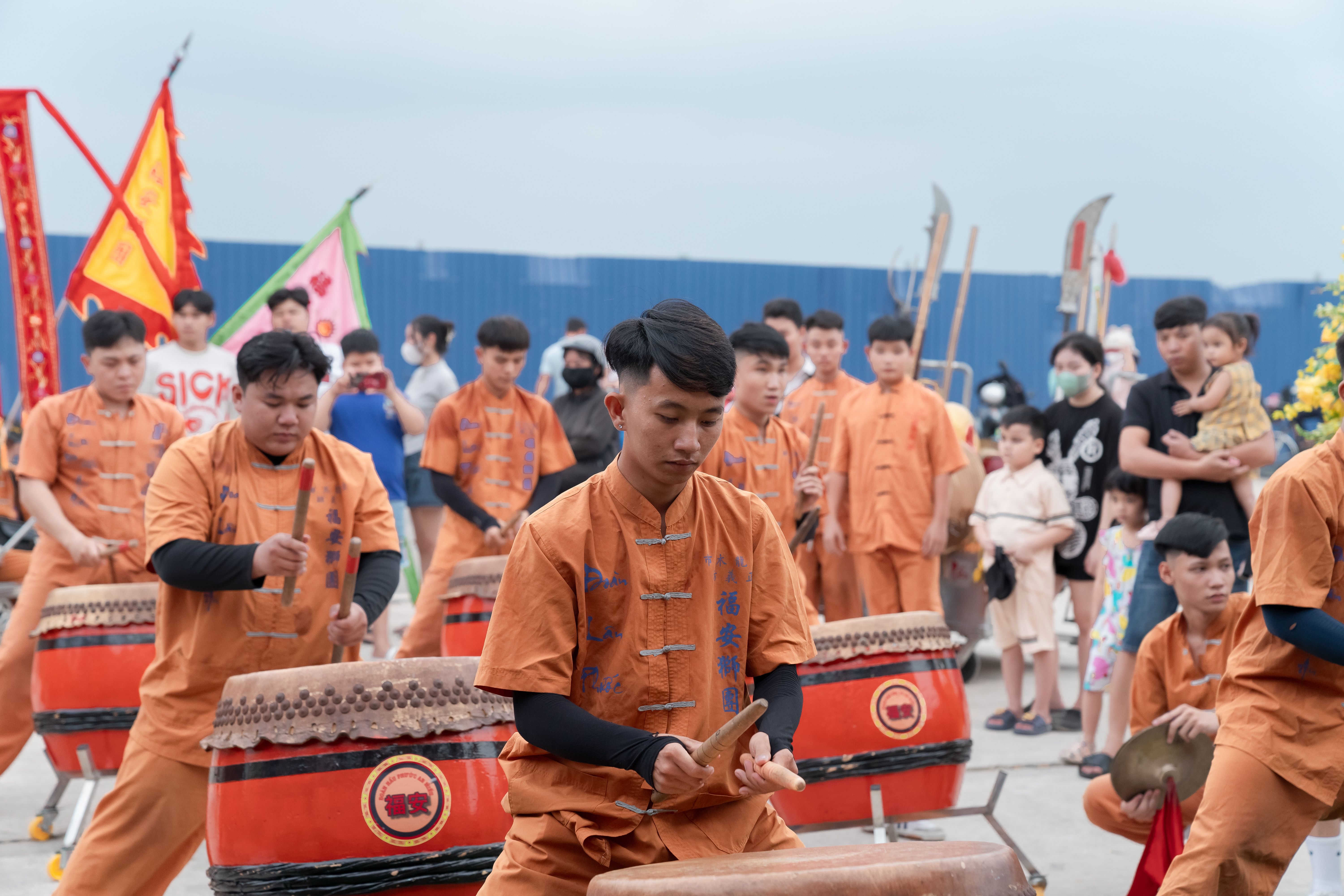 Hàng chục gà trống đứng trong các chuồng riêng biệt tại khu đất vắng lúc chiều muộn