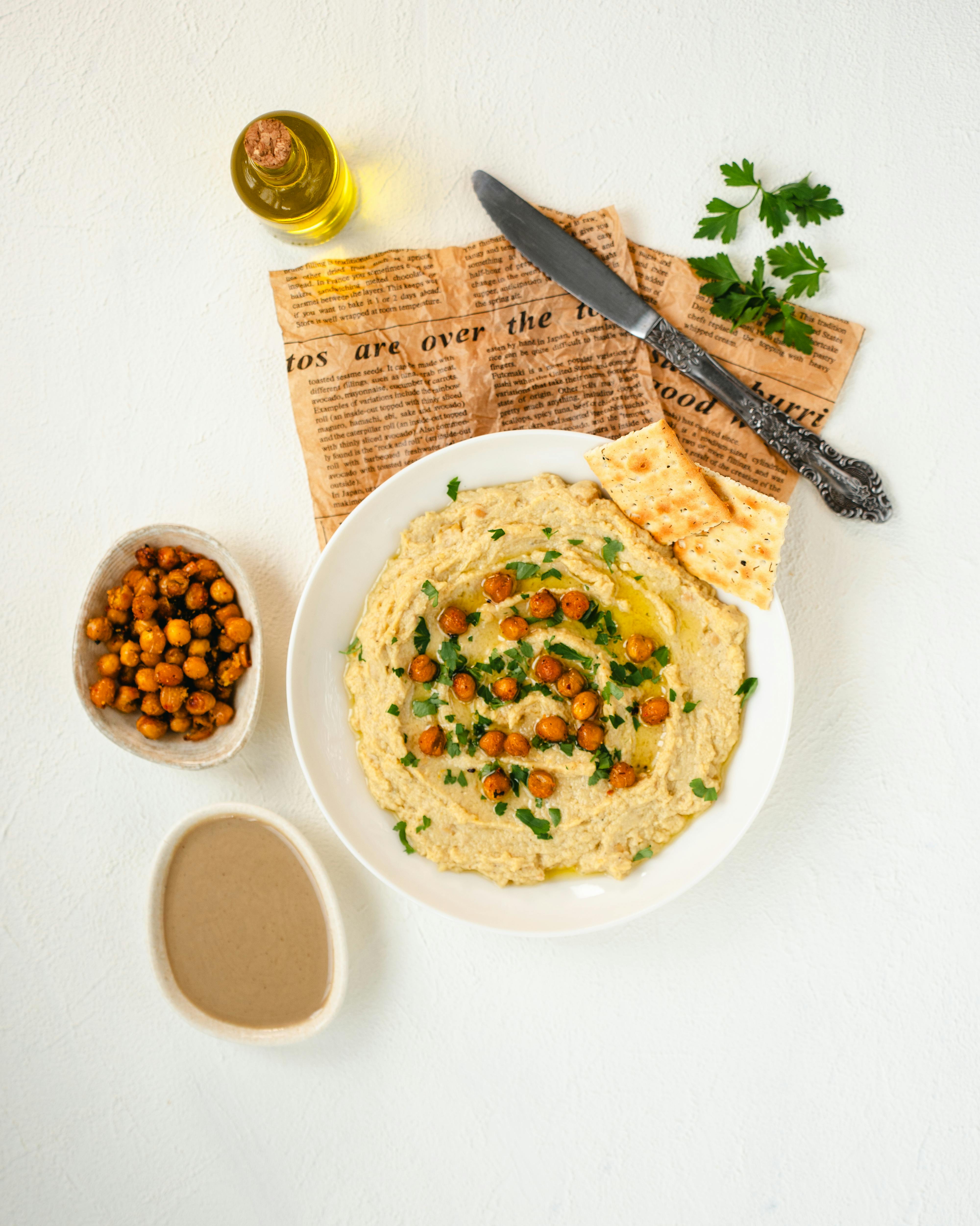 Flat-lay of hummus garnished with crispy chickpeas, parsley, and olive oil with flatbread.