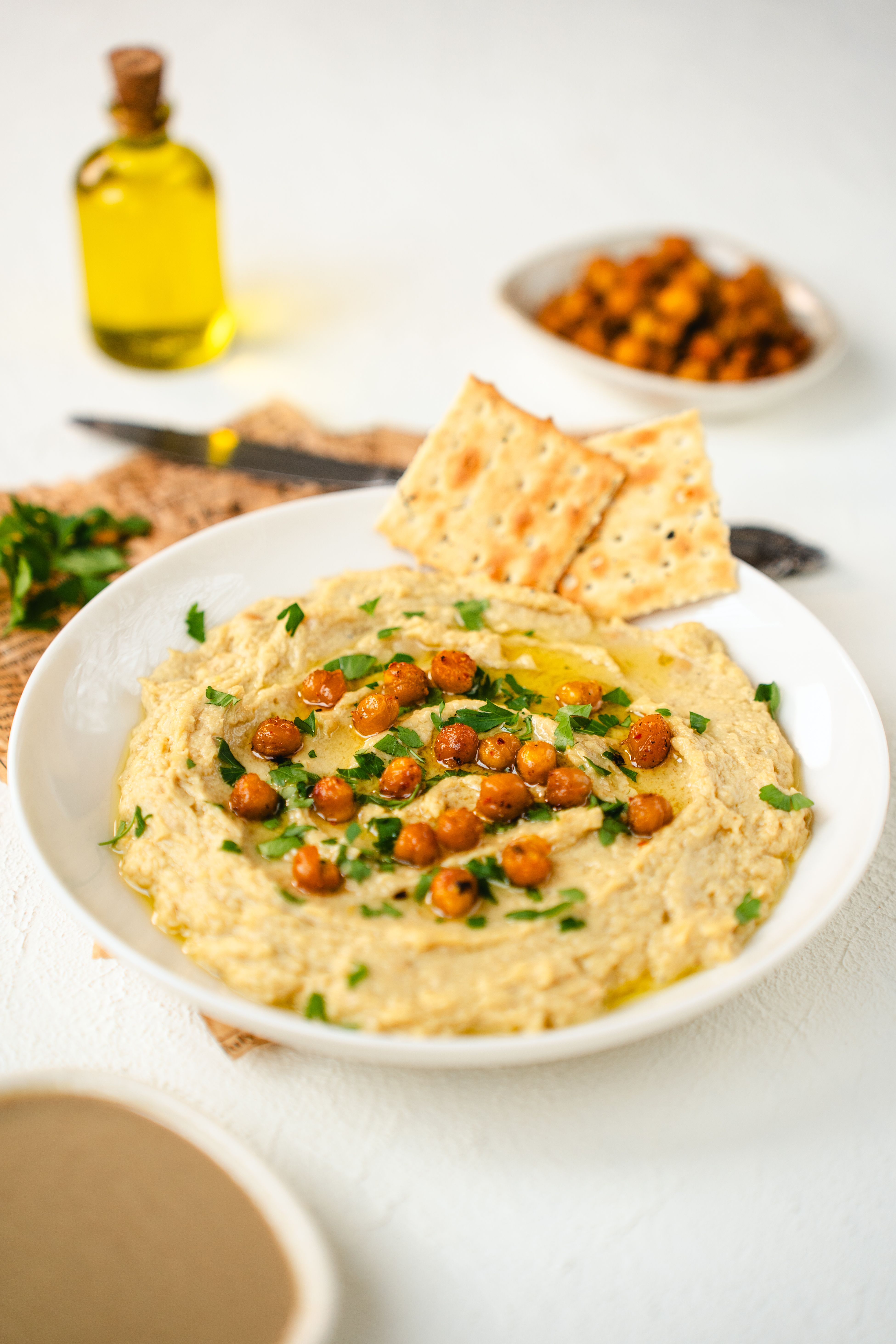 Plate of creamy hummus topped with crispy chickpeas and herbs, perfect for a Mediterranean appetizer.