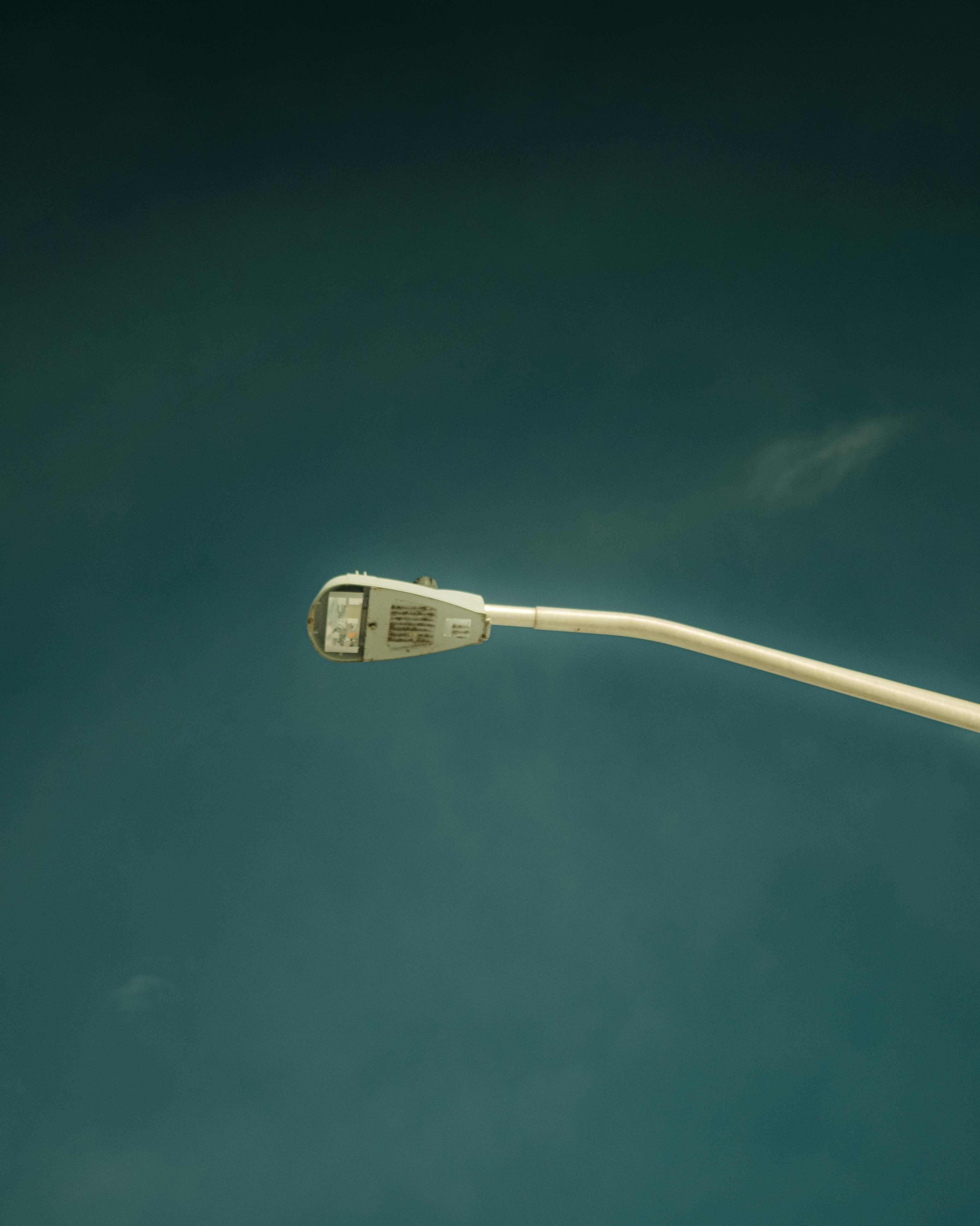 無料 広大な澄み切った青空を背景にした一本の街灯が、都会のミニマリズムを表現しています。 写真素材