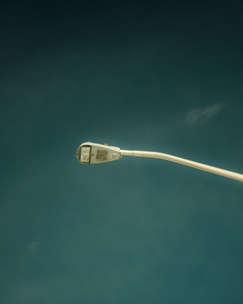 Free A single streetlight set against a vast clear blue sky, showcasing urban minimalism. Stock Photo