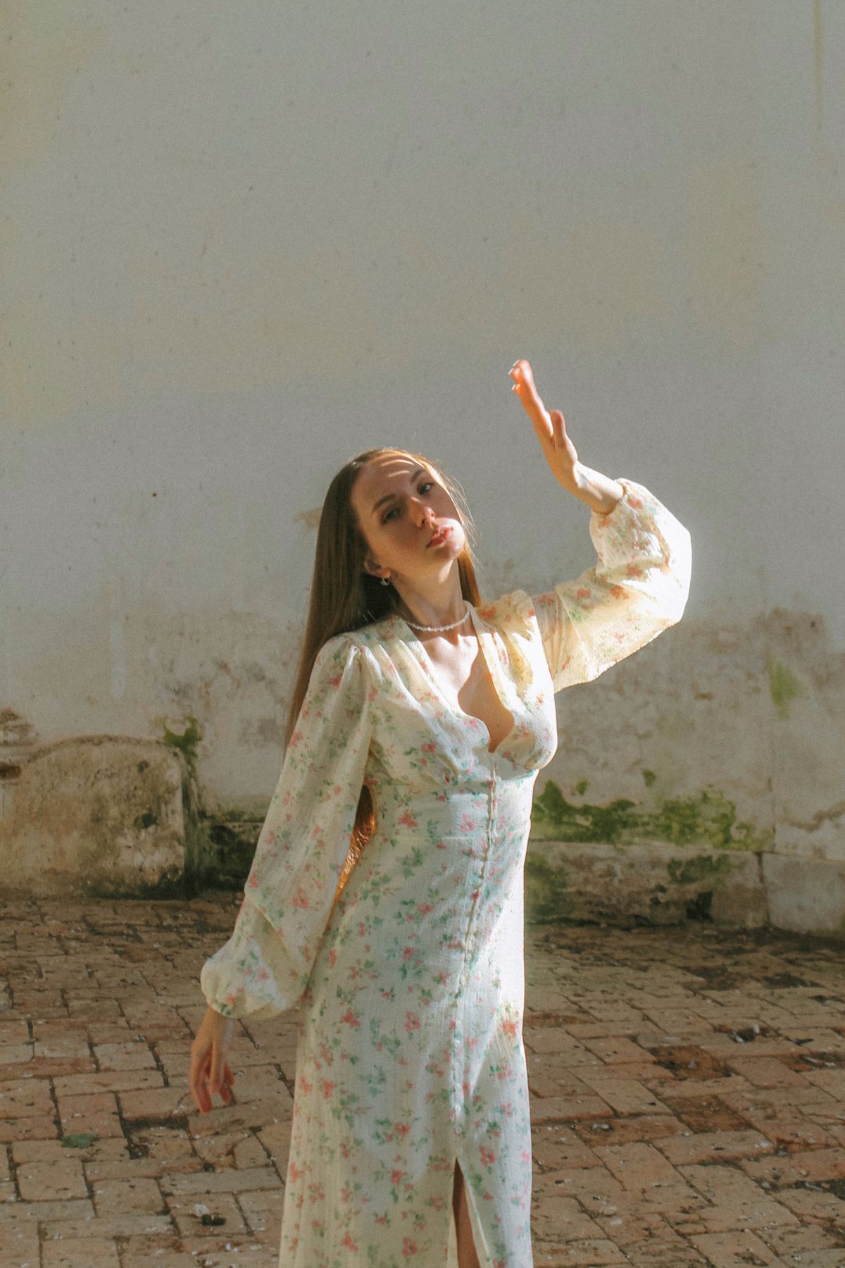 An elegant woman in a floral dress enjoying sunlight — In Bloom