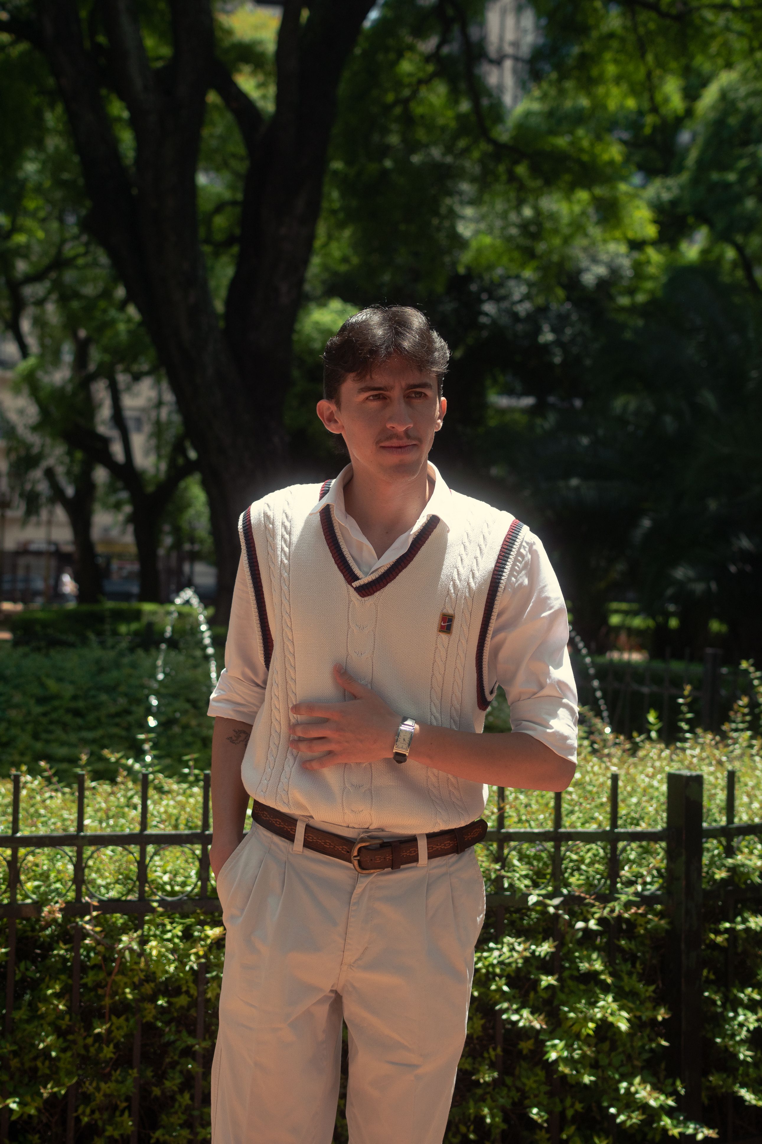 Portrait of a stylish young man enjoying a sunny day in Buenos Aires park.