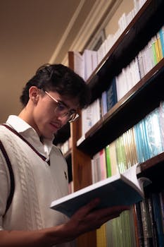 Stylish young man reading in a library in Buenos Aires, Argentina.
