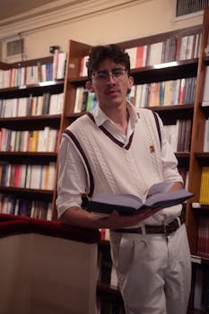 A young man in white attire reading at a elegant library in Buenos Aires, Argentina.