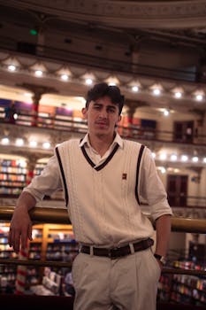 A fashionable young man confidently poses in El Ateneo Grand Splendid, Buenos Aires.