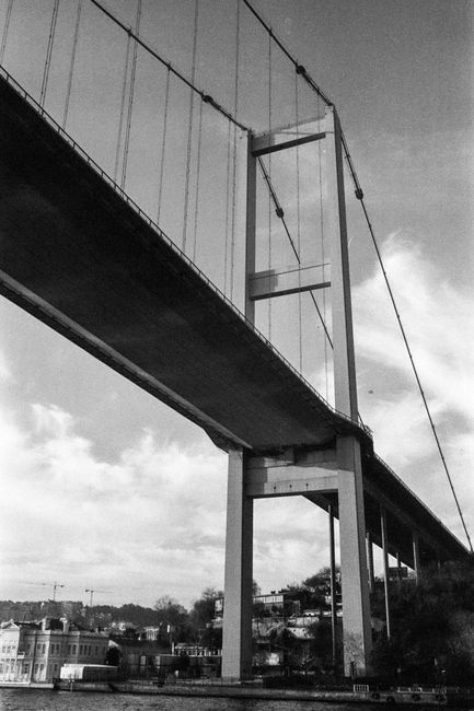 Artistic black and white view of a bridge in Istanbul, Türkiye, showcasing urban architecture.