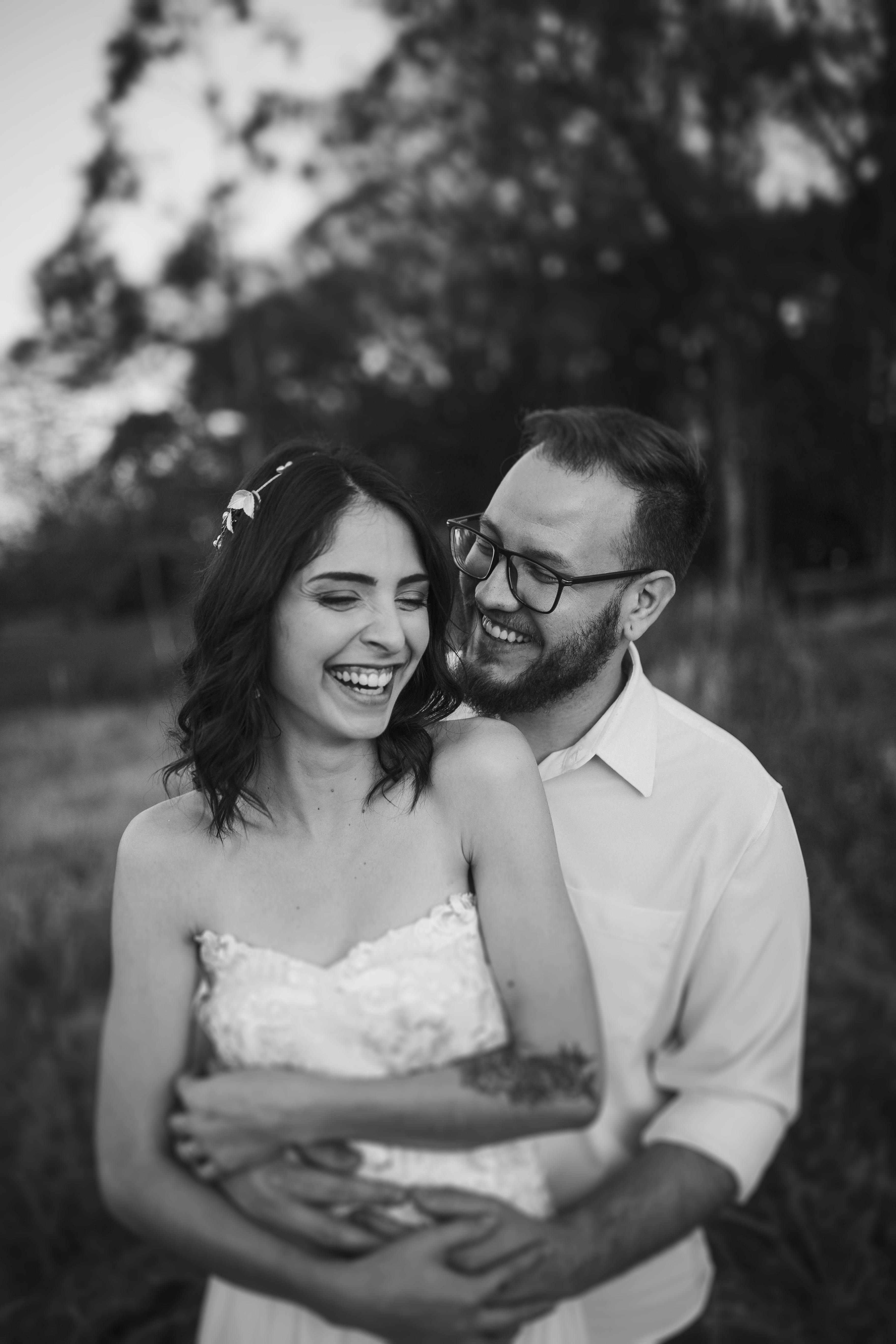 Free Grayscale Photography of Smiling Man Back Hugging Smiling Woman Stock Photo