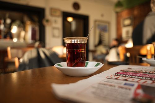 Free A glass of Turkish tea sits on a table in a cozy cafe with warm ambient lighting. Stock Photo