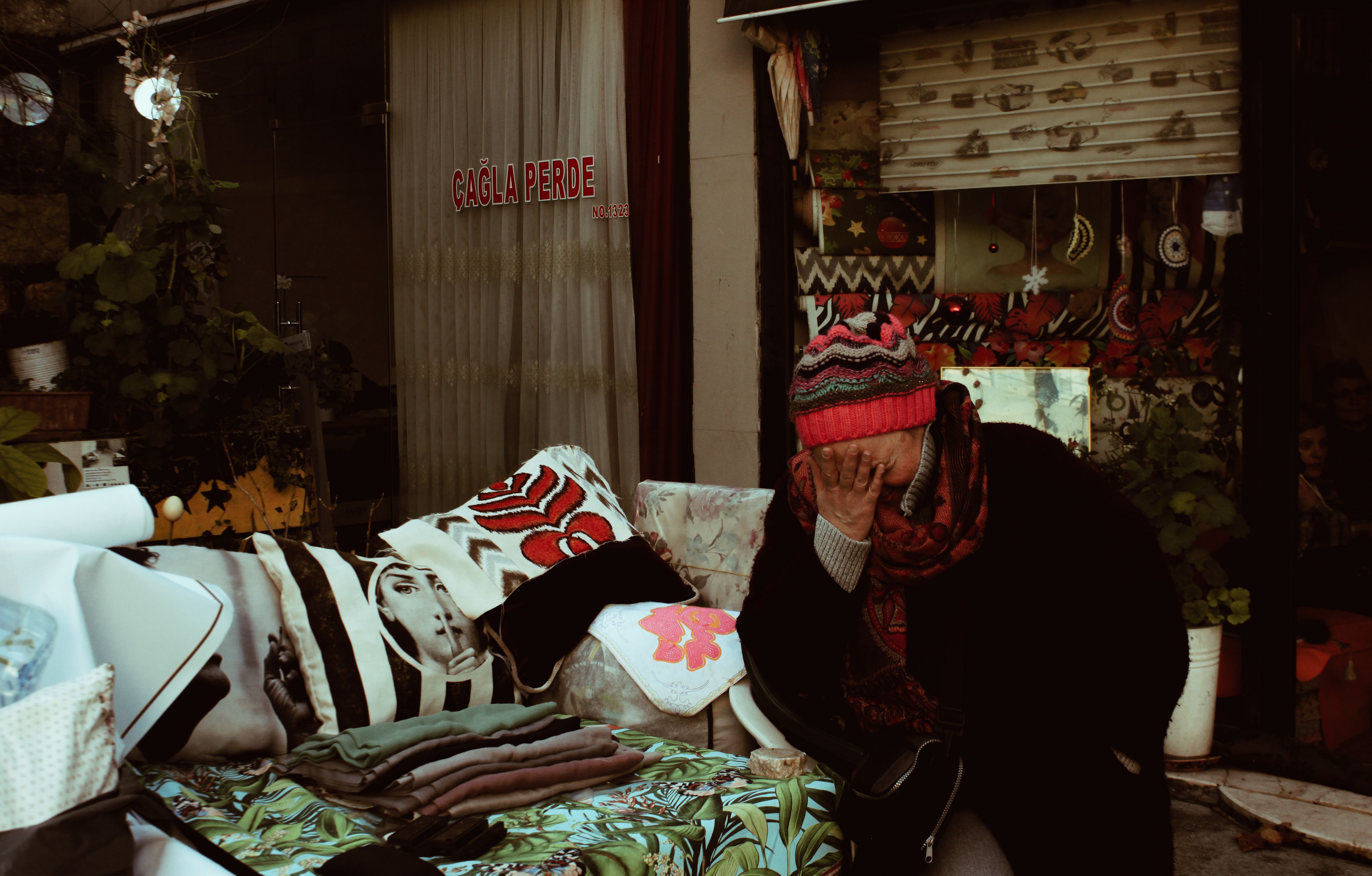 Cozy street scene in Istanbul with a vendor surrounded by colorful fabrics and plants, capturing local life.