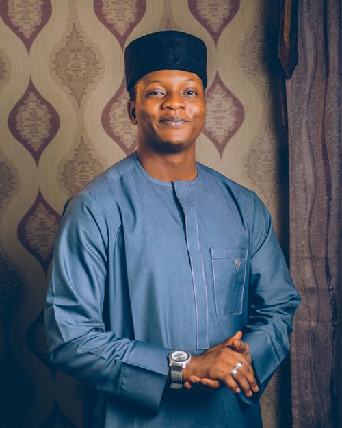 Free Smiling man in traditional attire with a patterned backdrop, showcasing cultural style. Stock Photo