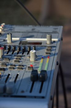 Detailed view of an audio mixing console in natural light.
