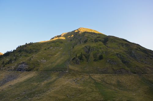 Free A stunning mountain landscape captured during golden hour, highlighting lush greenery and a clear blue sky. Stock Photo