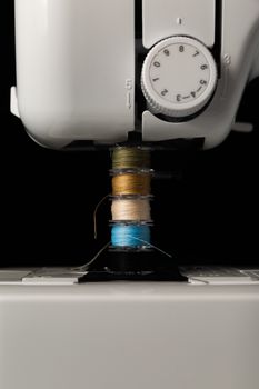 Close-up of a sewing machine with spools of colorful thread, perfect for fashion and DIY projects.
