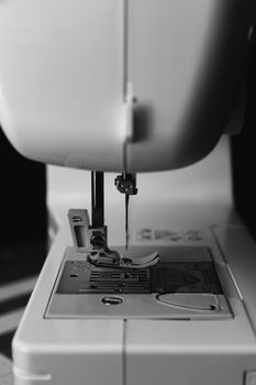 Black and white close-up of a sewing machine needle, focusing on craftsmanship and sewing tools.