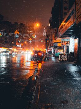 A vibrant, colorful street scene during a snow-dusted night capturing urban life.