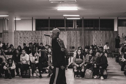 Free Black and white photo of a hip hop artist performing in front of a student audience in Brazil. Stock Photo