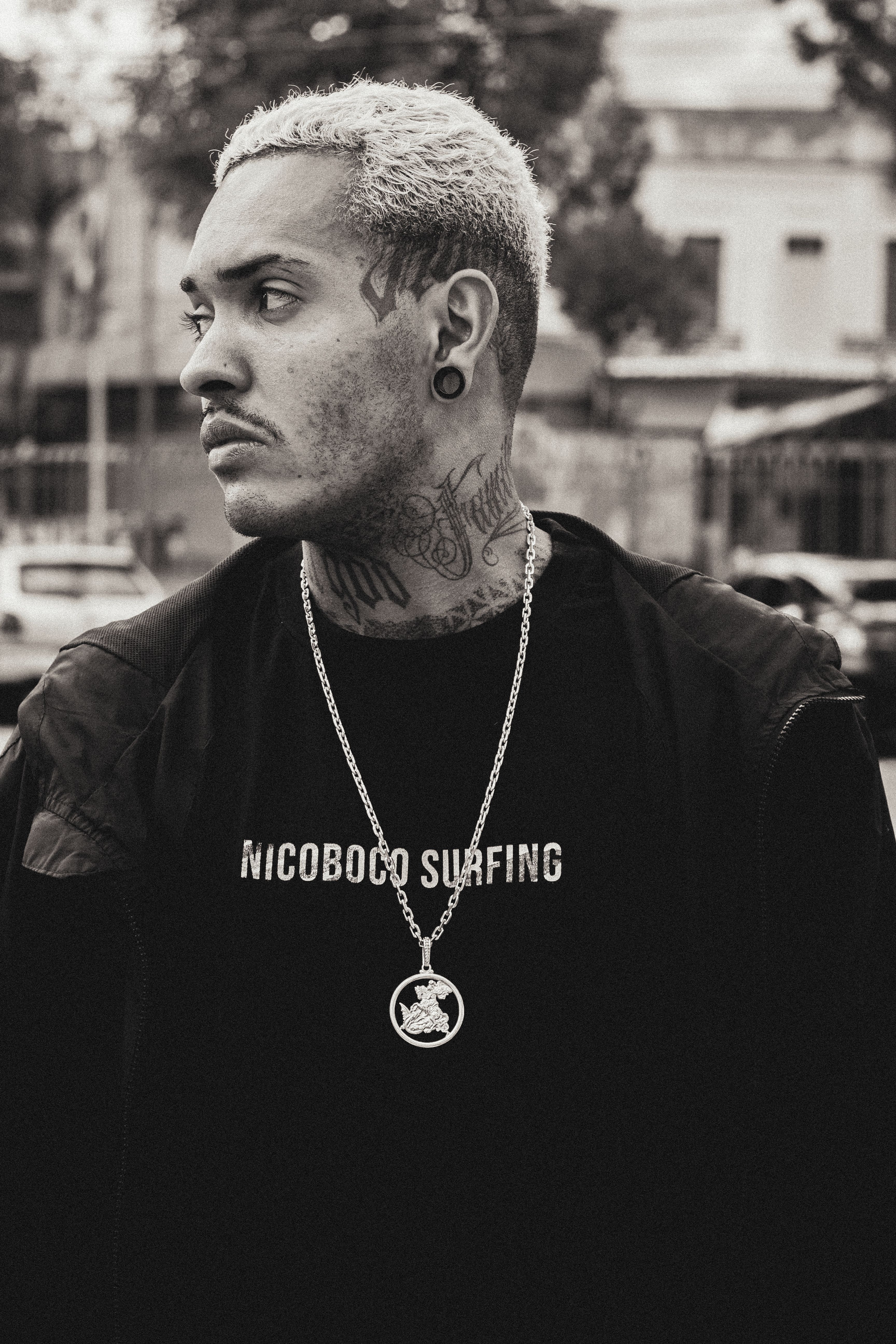 Monochrome portrait of a tattooed man outdoors in São Paulo.