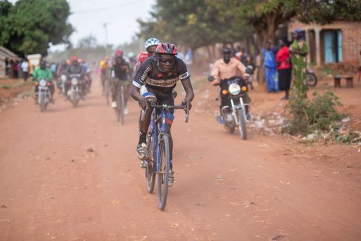 A thrilling cycling race unfolds on a dirt road in Africa, capturing the essence of competition and endurance.