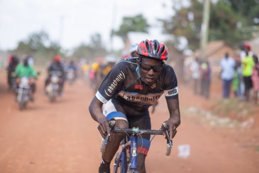 Competitive cyclist on a rural dirt road, showcasing endurance and determination.