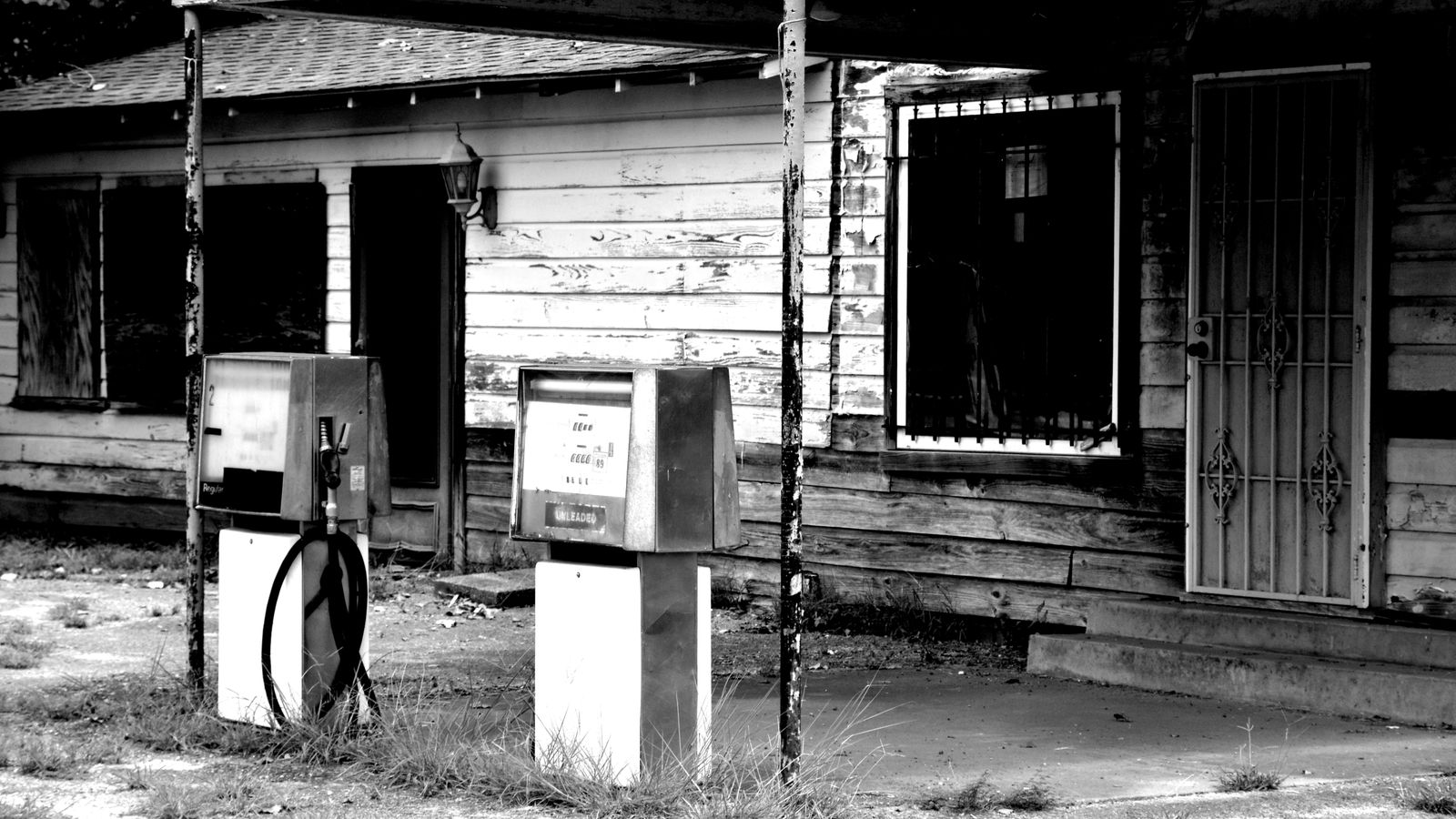 Black and white photo of an abandoned gas station in Troup, Texas, showcasing vintage architecture.