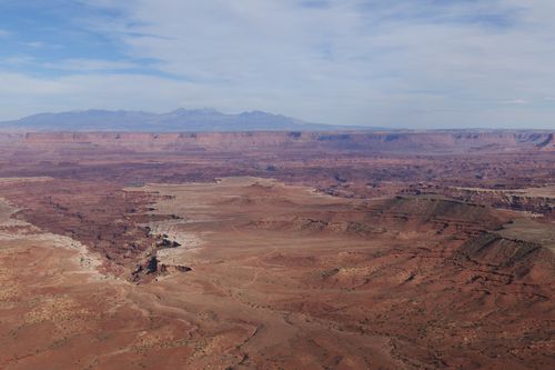 Free Spectacular aerial shot of a vast, arid desert landscape under a clear sky. Stock Photo