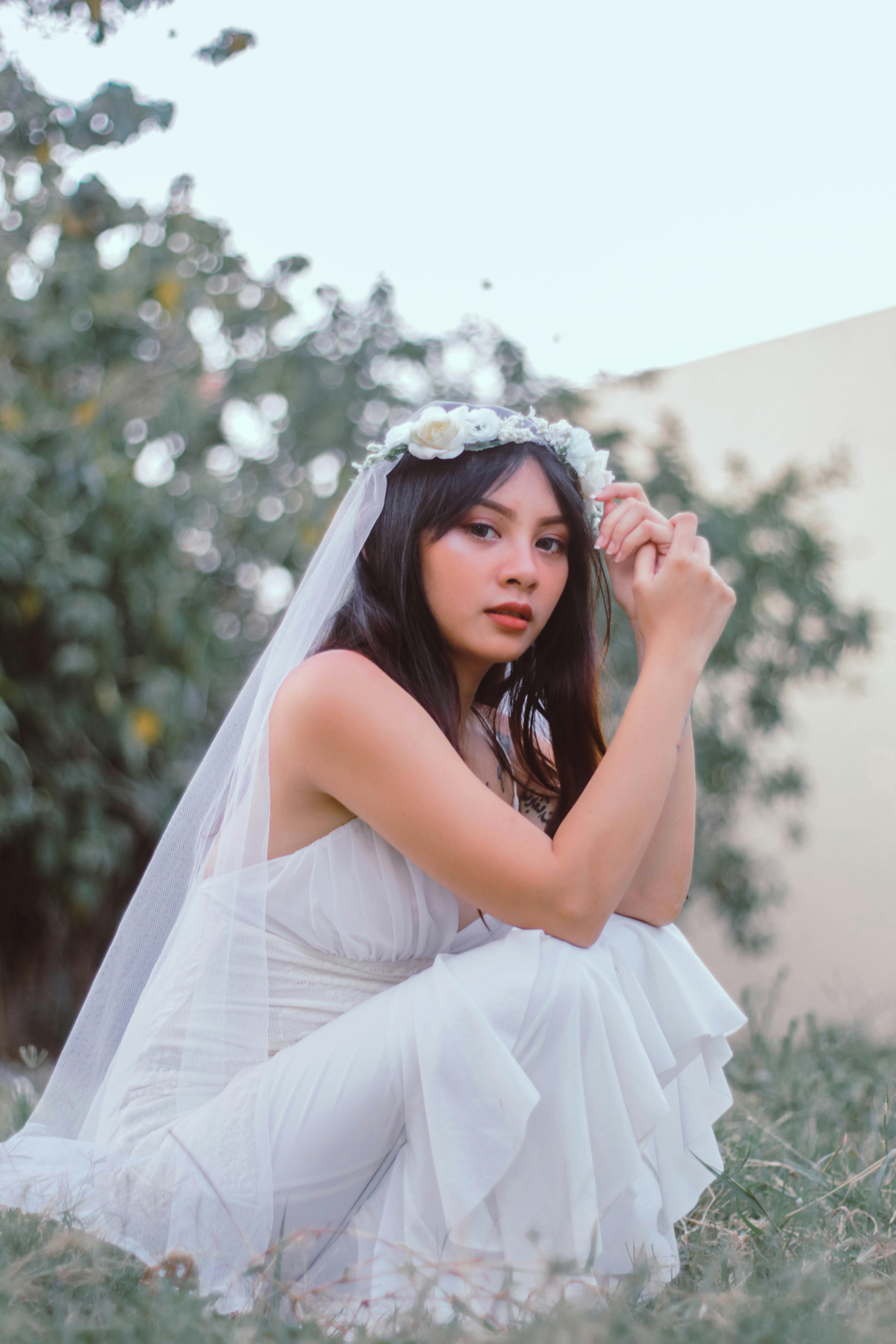 花园里，一位身着飘逸白色连衣裙、头戴花卉头饰的新娘，肖像宁静