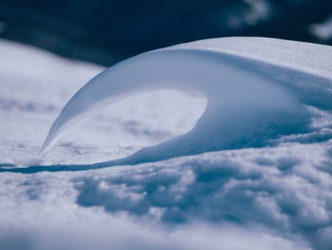 A mesmerizing frozen wave sculpted by snow, showcasing nature's artistry in winter.