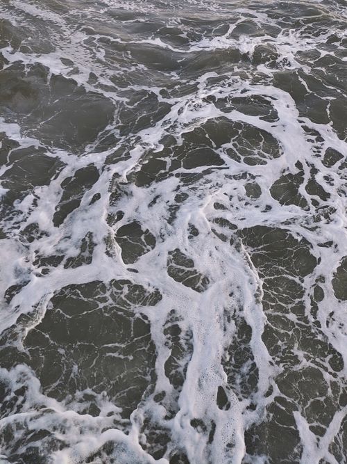 Free Captivating view of ocean waves with intricate foam patterns, evoking a sense of movement and serenity. Stock Photo