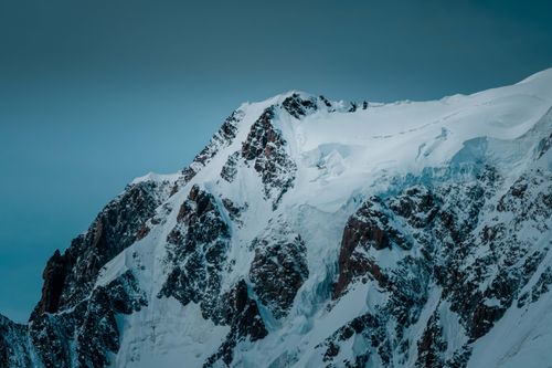 Free Stunning view of a snow-capped mountain peak with pristine icy slopes under a clear winter sky. Stock Photo