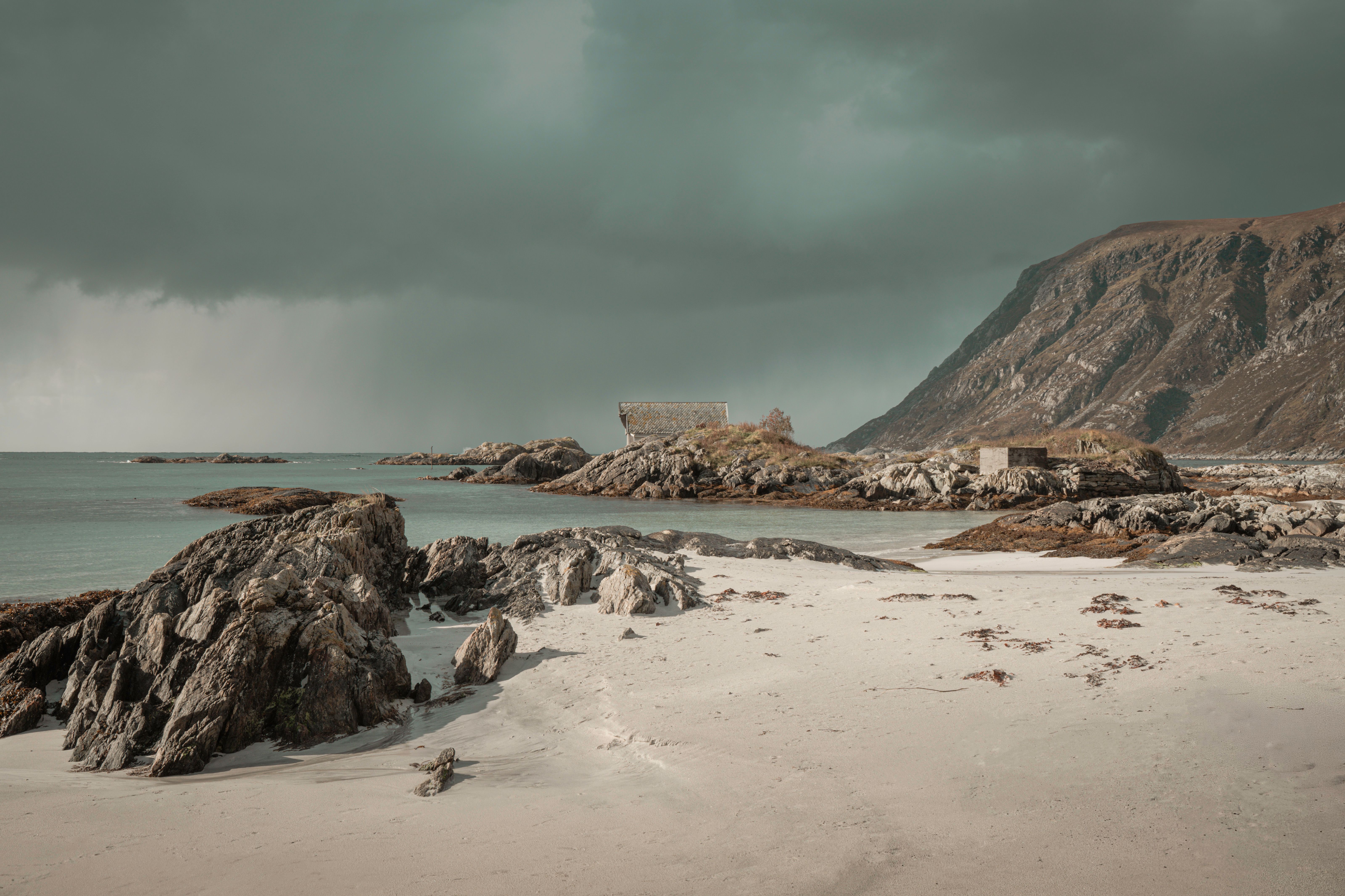 Scenic Coastal Landscape with Rocky Shore and Mountain · Free Stock Photo