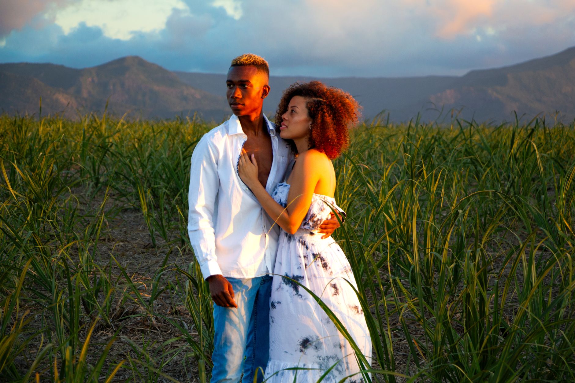 A couple embraces in a lush sugarcane field in Mauritius during sunset.