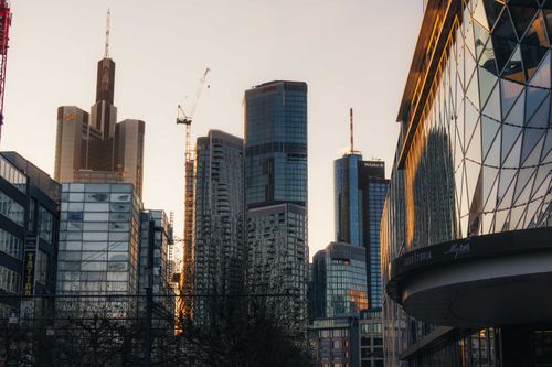 Free Frankfurt's skyline with modern skyscrapers and cranes at sunset. Stock Photo