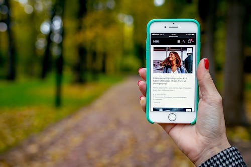 Free Shallow Focus Photo of Person Holding Smartphone Stock Photo