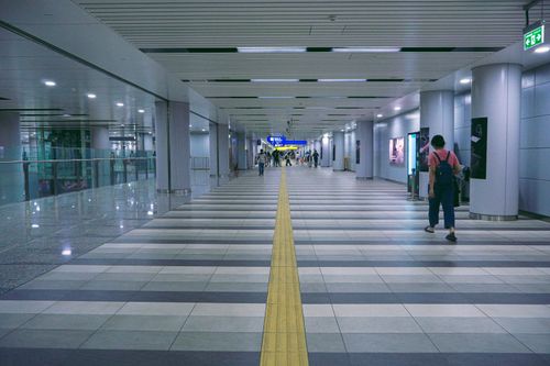 Free Spacious underground subway walkway with people and signage, ideal for urban travel themes. Stock Photo