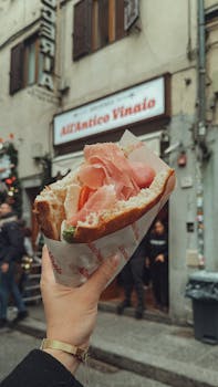 Close-up of a delicious Italian sandwich in front of All'Antico Vinaio in Florence.