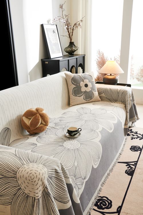 Free A cozy living room with a floral sofa cover, cushions, and a warm ambiance. Stock Photo