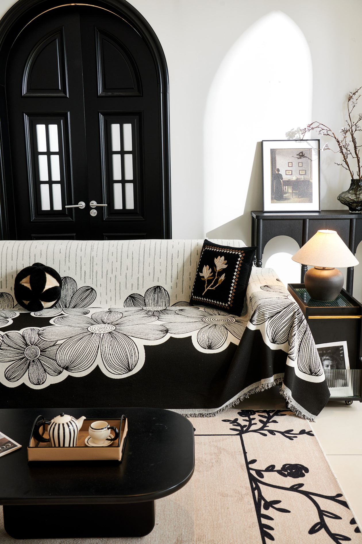 Black-and-white floral sofa styled in a classic bright living room